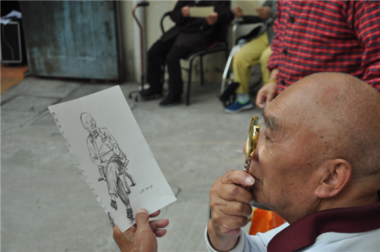 老人在认真看画像  蒋正摄
